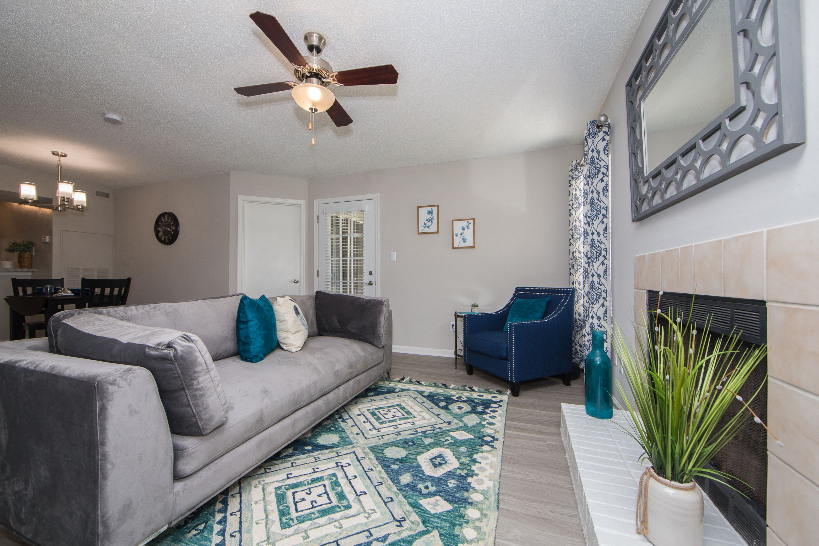 a living room with a couch and a chair and a ceiling fan